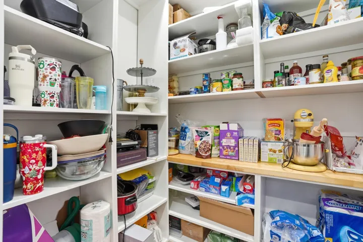 Built-in shelving with multiple levels, wood-finish countertop, and ample storage capacity