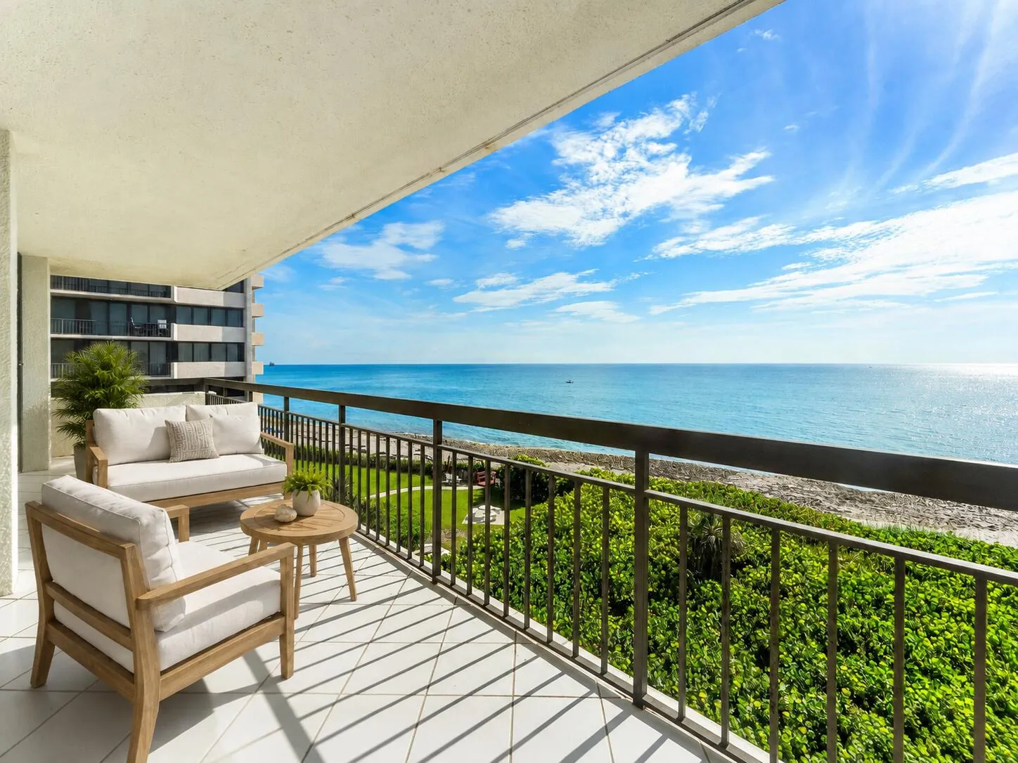 Long covered terrace runs beside the residence's broad glass frontage, emphasizing the exceptional amount of ocean-facing outdoor space.