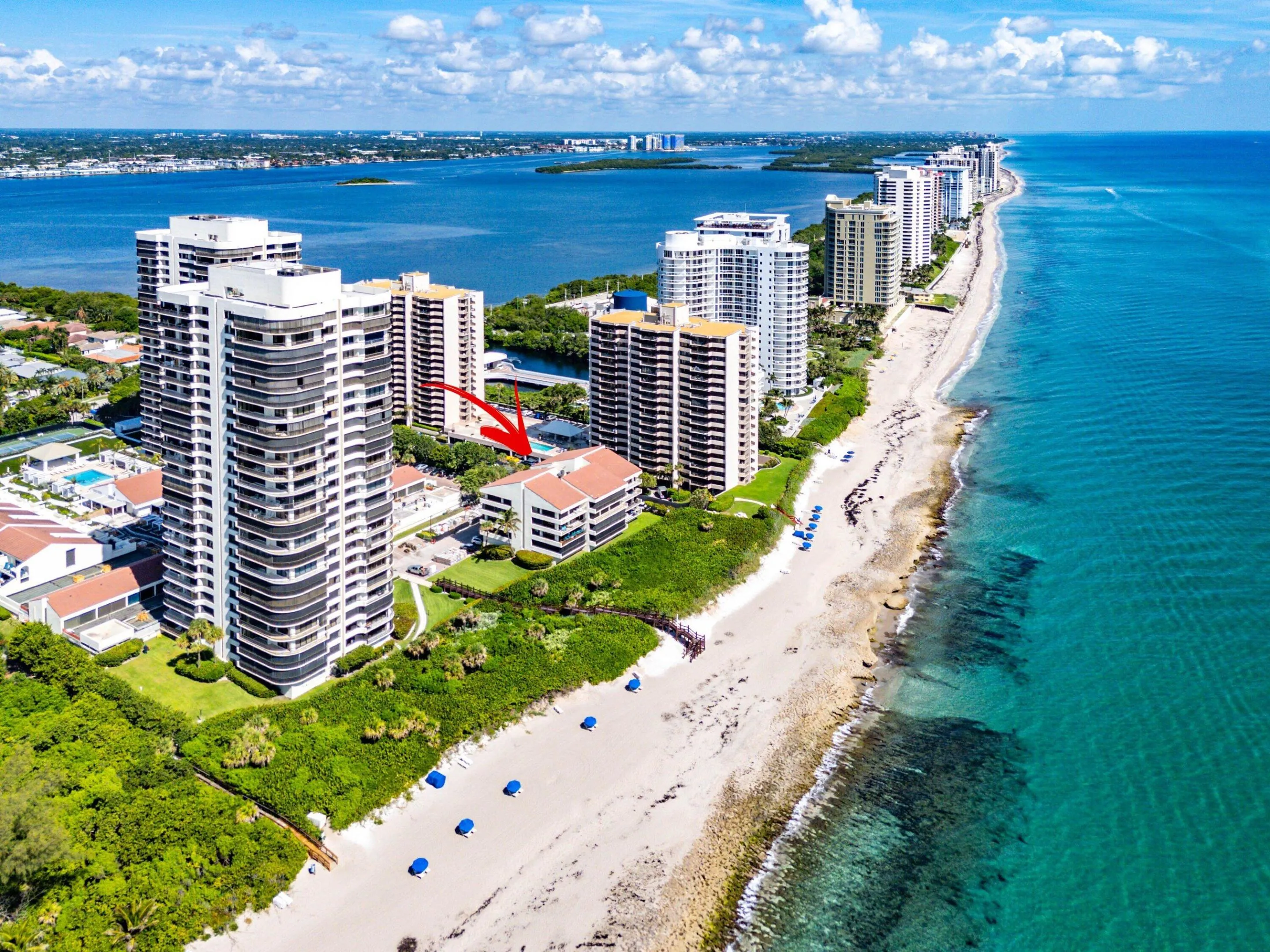 Aerial reveals Ocean House's intimate low-rise scale and its position immediately behind the beachfront dunes.