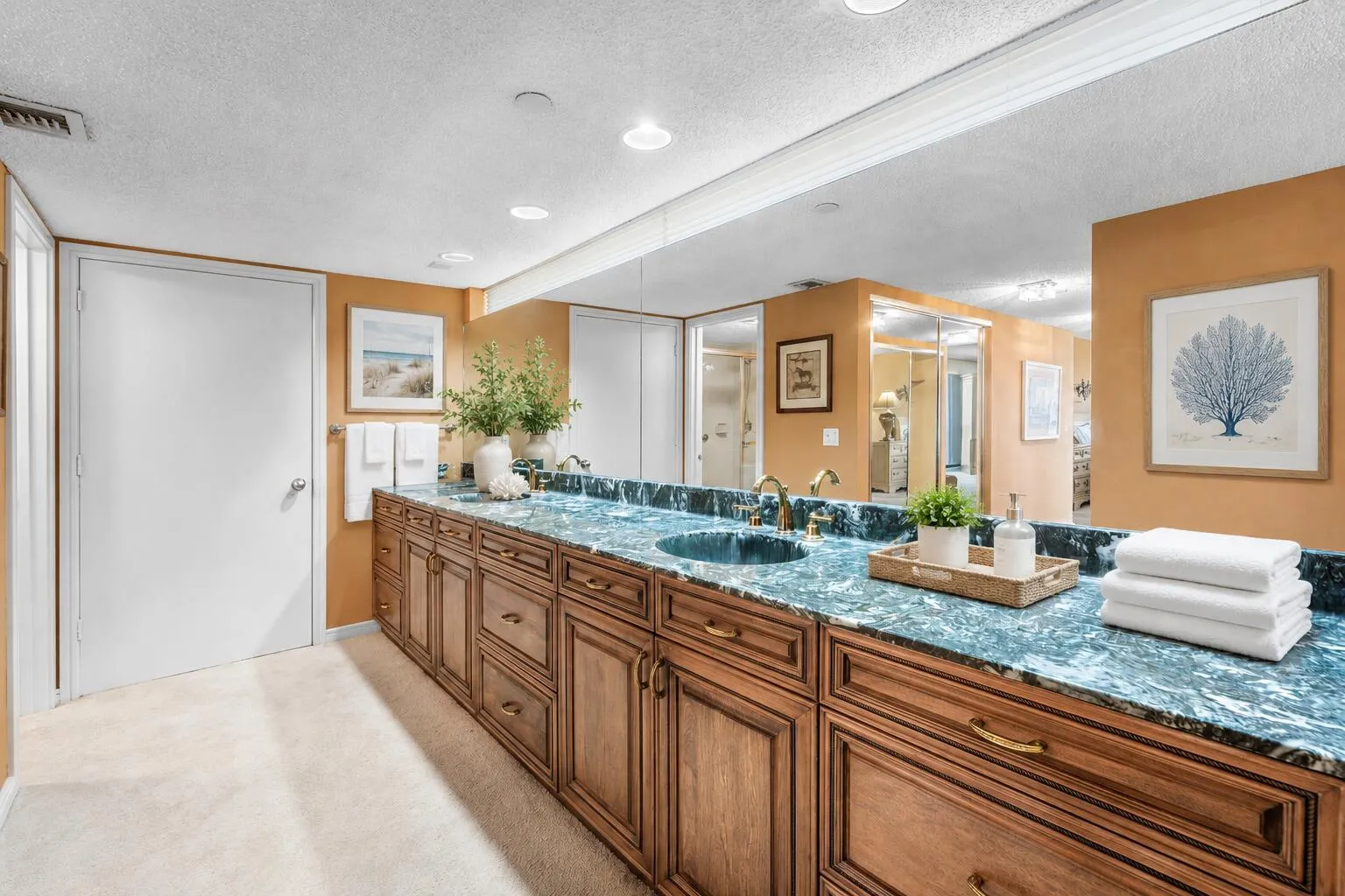 Master Bathroom: Long dual-sink vanity offers extensive counter space, cabinetry and mirrored surfaces.
