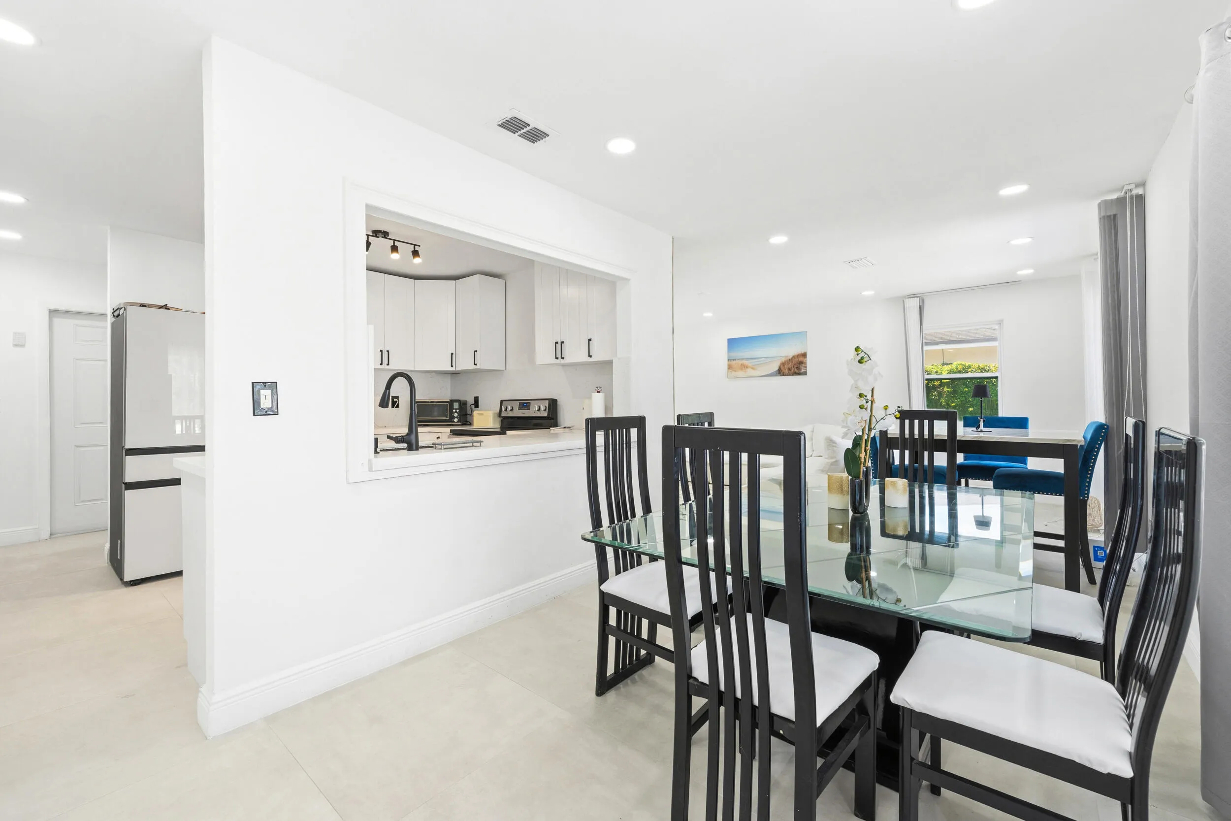 Bright interior with recessed lighting, tile flooring, and a kitchen pass-through window