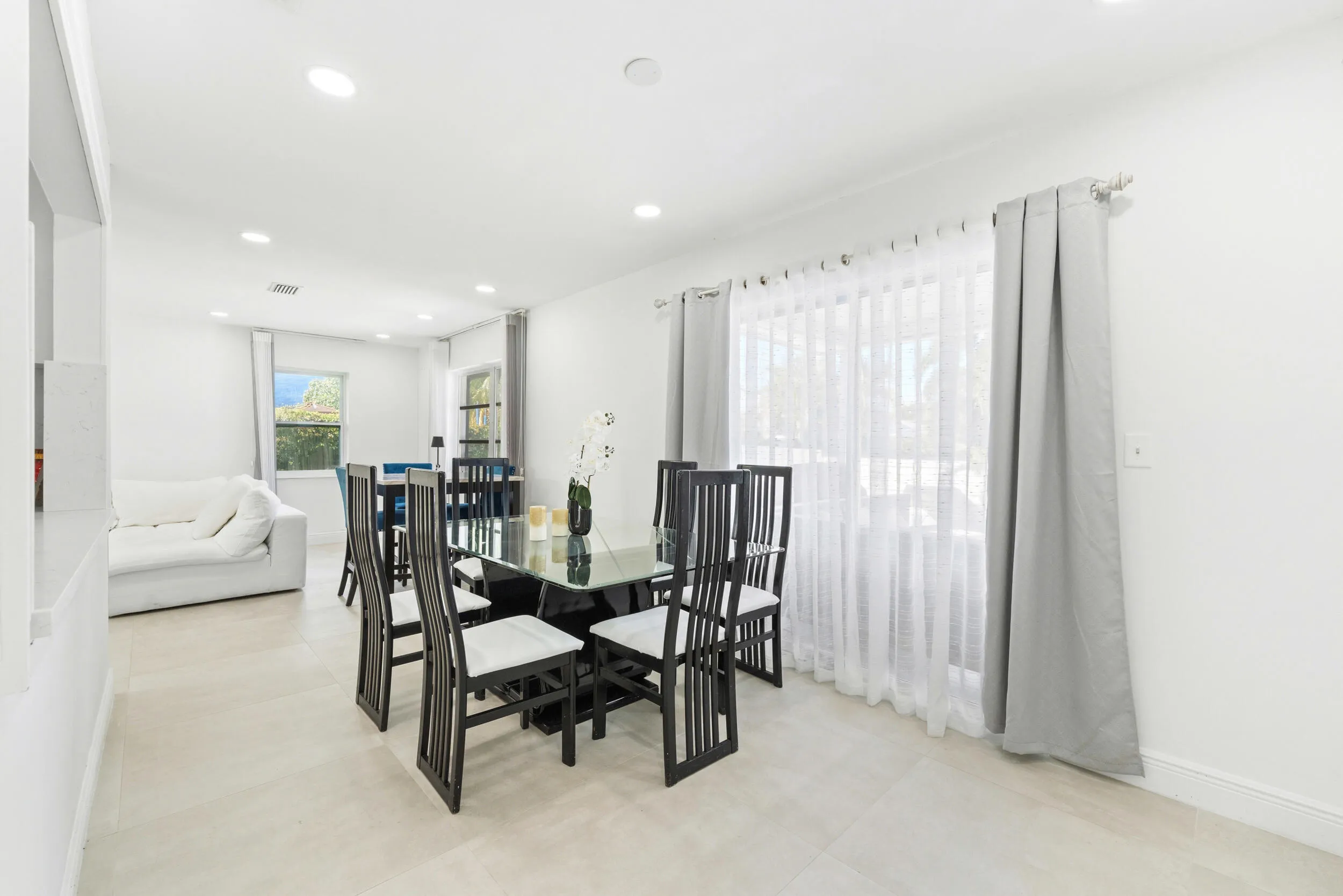 Recessed lighting illuminates neutral tile flooring and white wall finishes