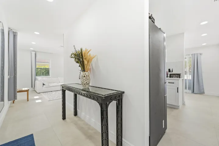 Recessed lighting illuminates the neutral wall tones and tile flooring