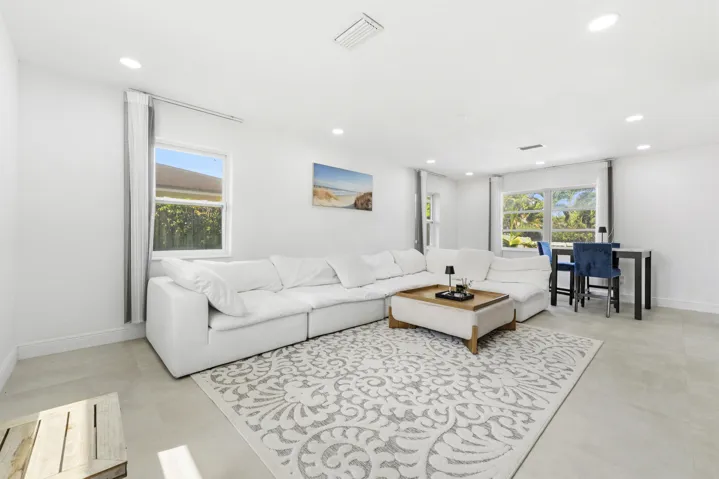 Recessed lighting, light-toned tile flooring, and multiple windows with white trim