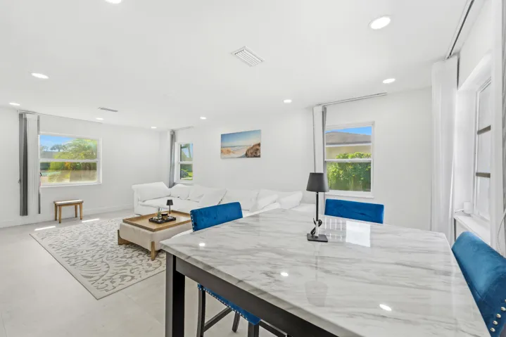 Open-concept living space with recessed lighting, multiple windows, and light-toned flooring