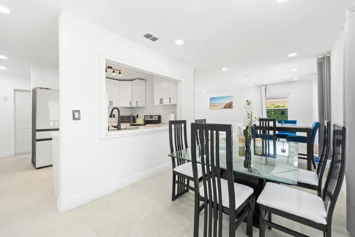 Bright interior with recessed lighting, tile flooring, and a kitchen pass-through window