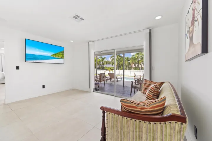 Recessed lighting, tile flooring, and sliding glass doors opening to a patio and pool area