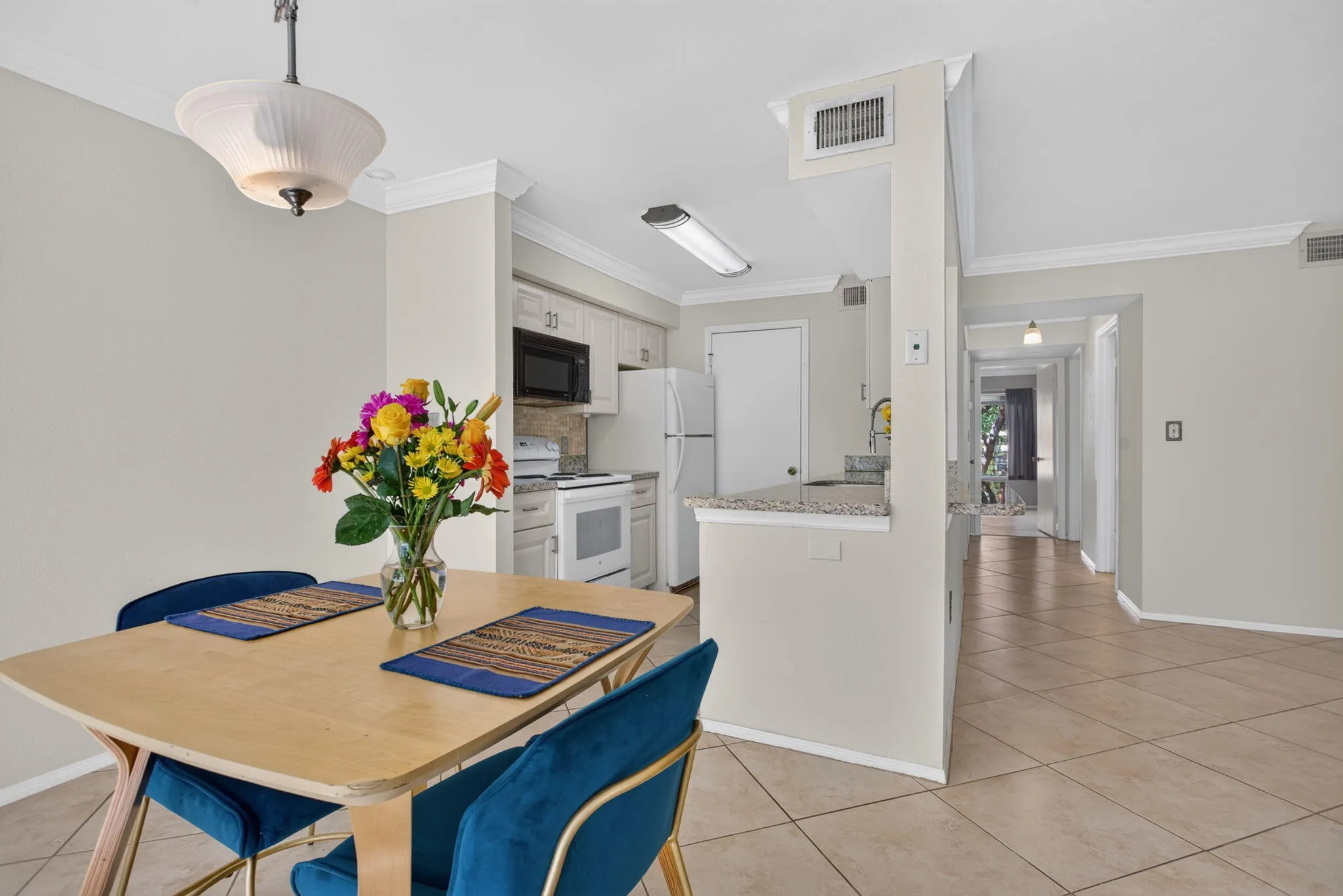 Kitchen with light cabinetry, built-in microwave, and white appliances