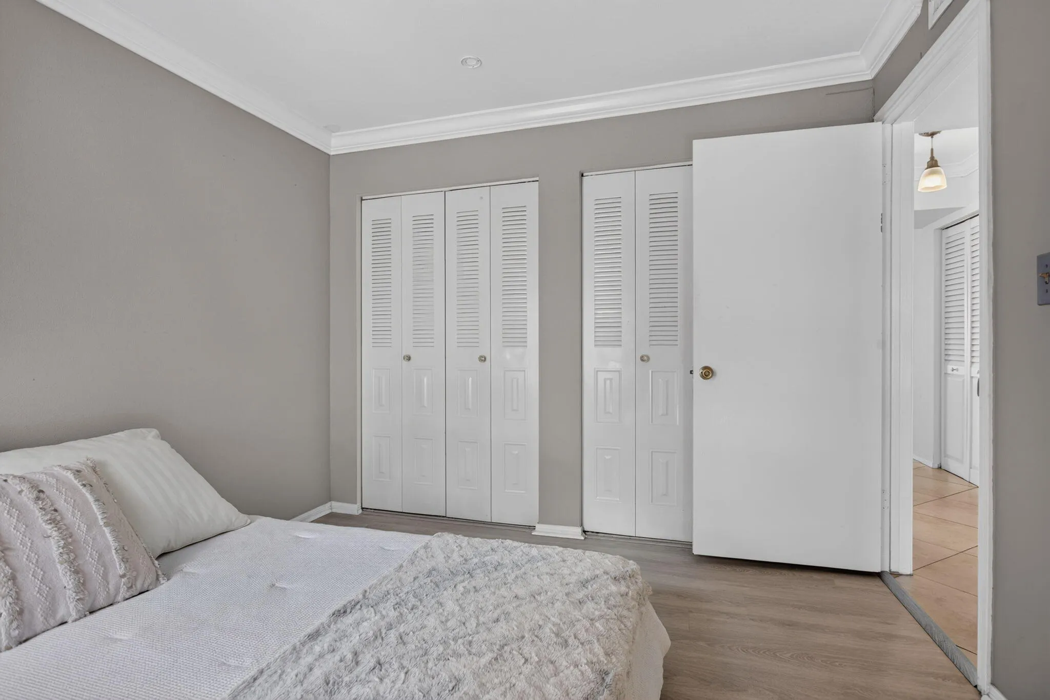 Wood-finish flooring, crown molding, and neutral wall tones