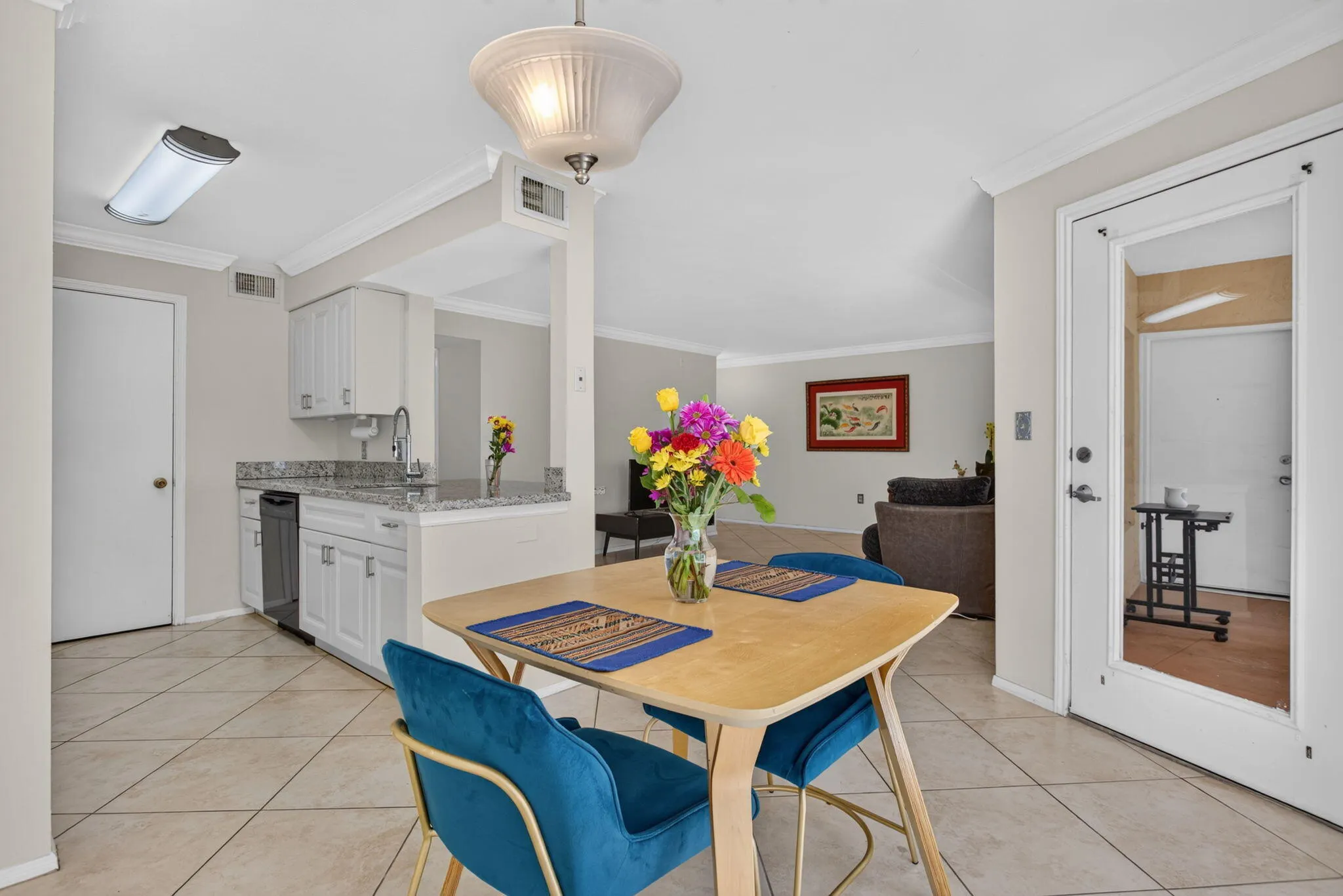 Kitchen area featuring white cabinetry, a double basin sink, and light-toned countertops