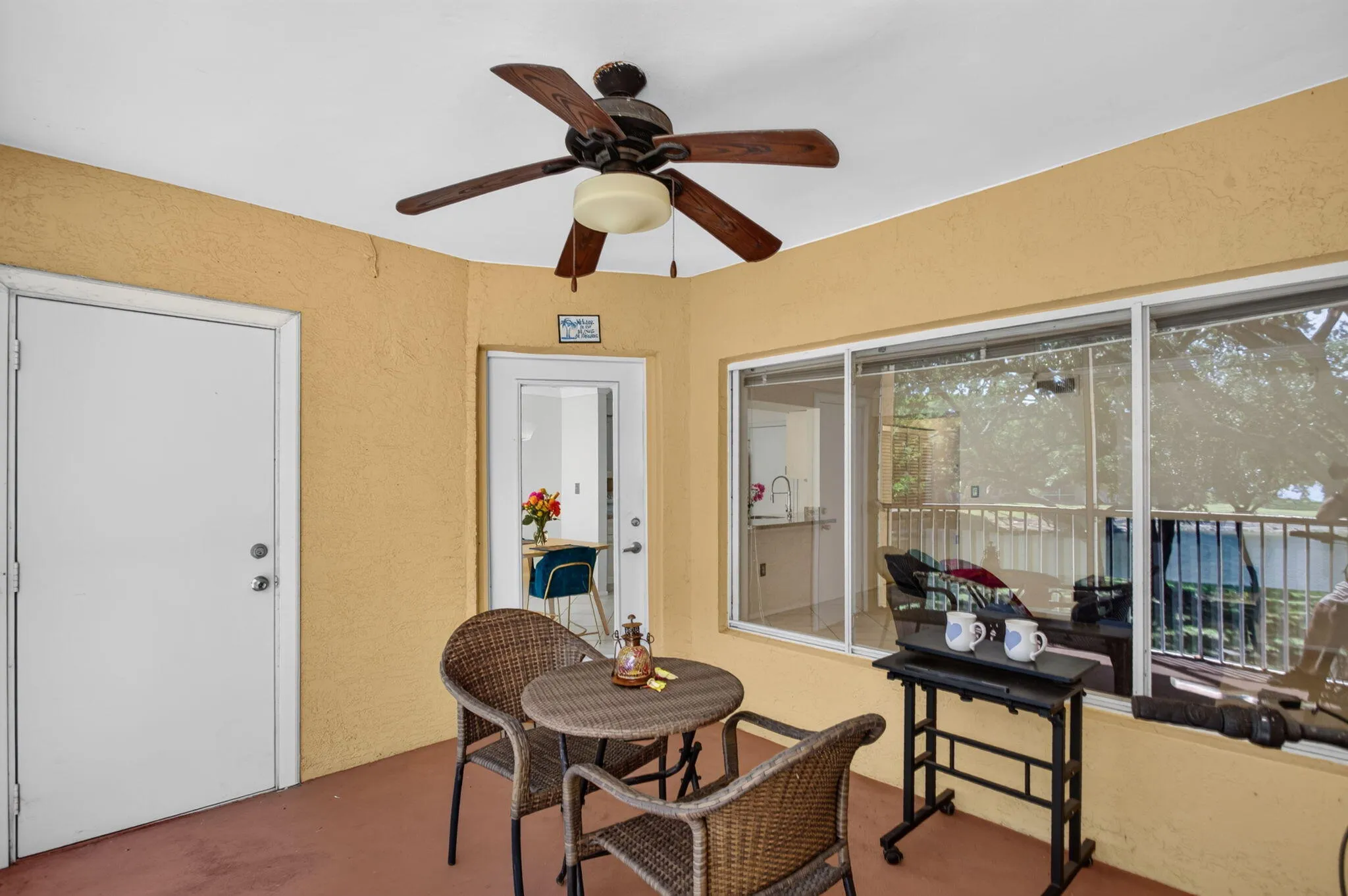 Screened patio with a ceiling fan, textured exterior walls, and a finished floor