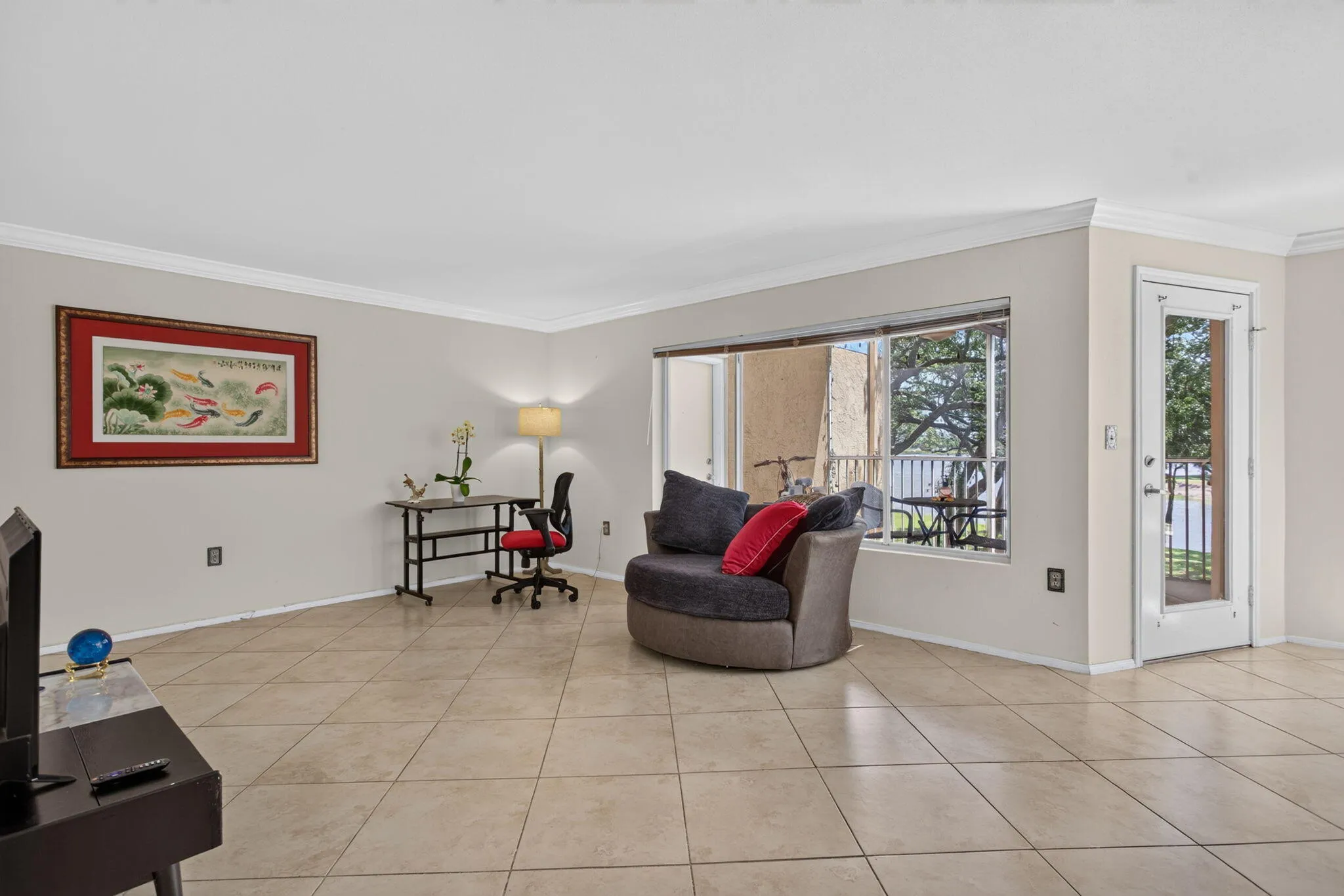 Spacious interior with tile flooring, large windows, crown molding, and a glass-paneled door