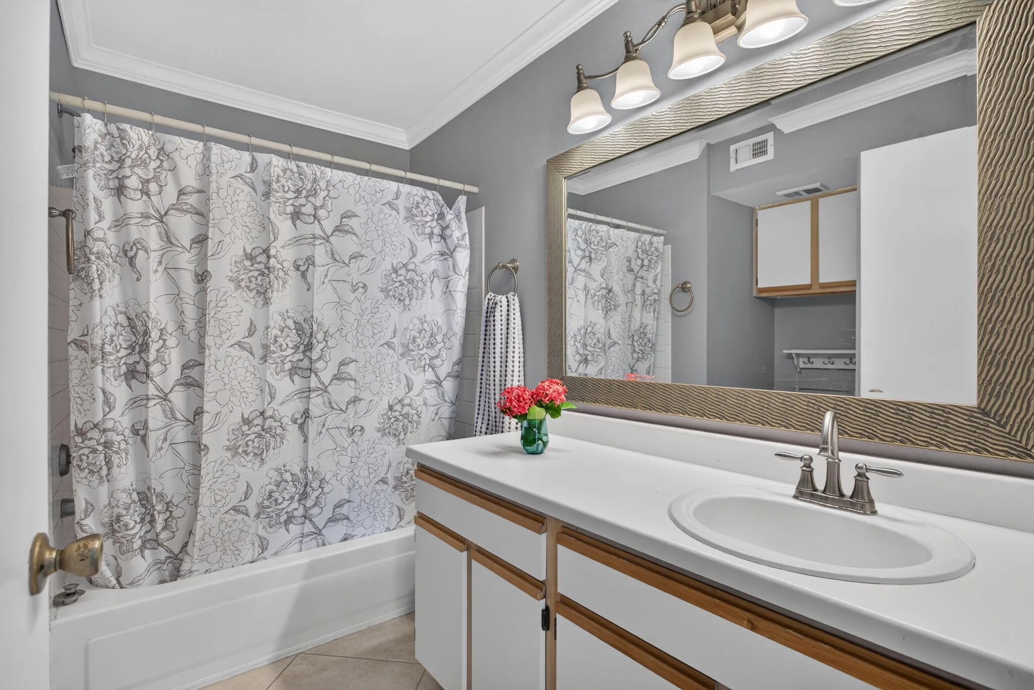 White vanity with an integrated sink, brushed nickel faucet, and wood-framed mirror