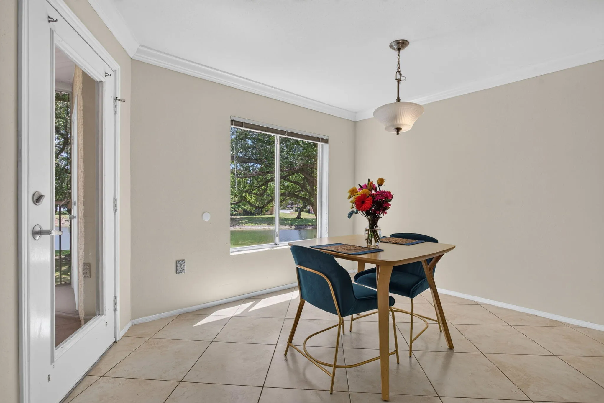 Recessed window with exterior landscaping, crown molding, and tiled flooring
