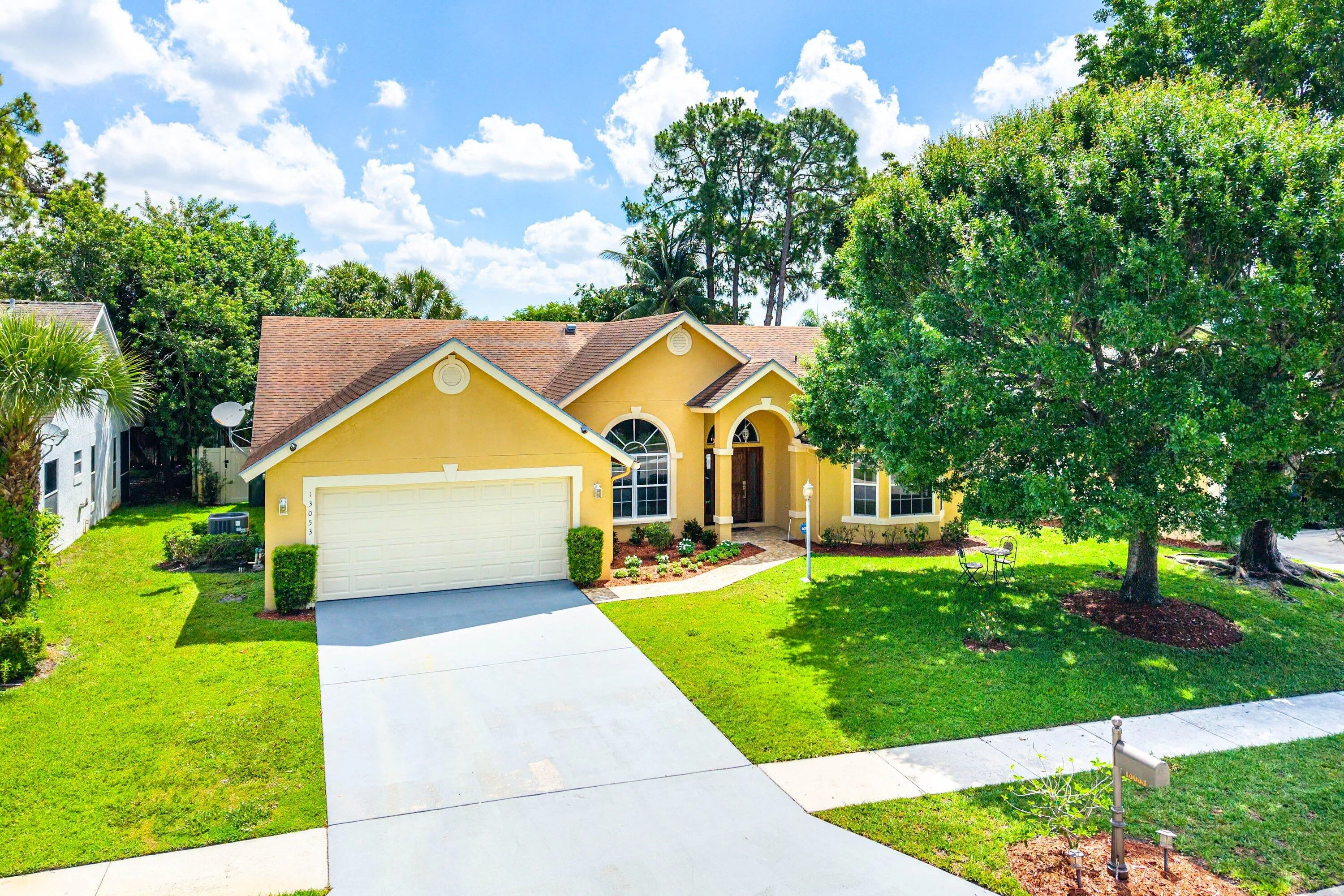 Single-story residence with a two-car garage, arched entry, and a prominent front door