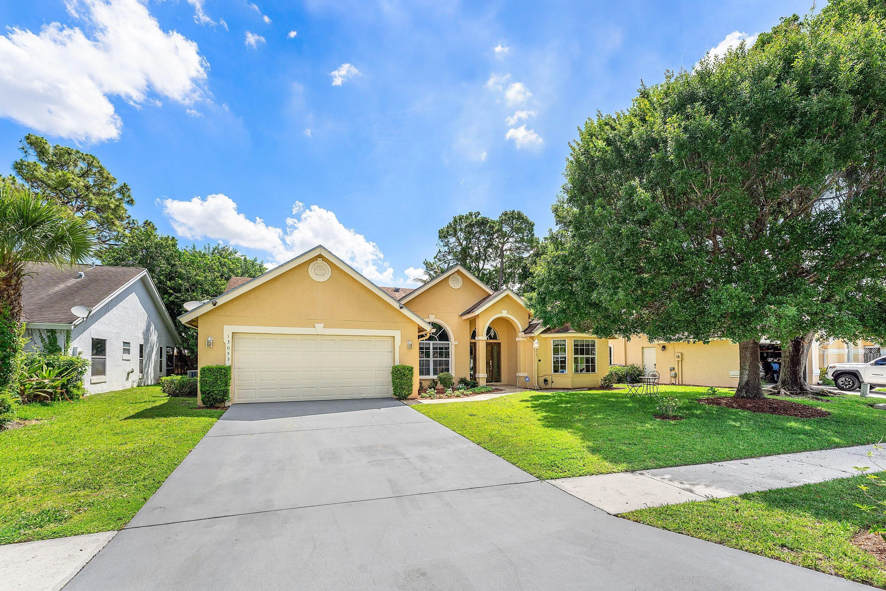 Single-story residence featuring a painted exterior, arched entry, and an attached two-car garage