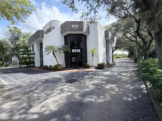 White stucco exterior with dark trim and large street numbering