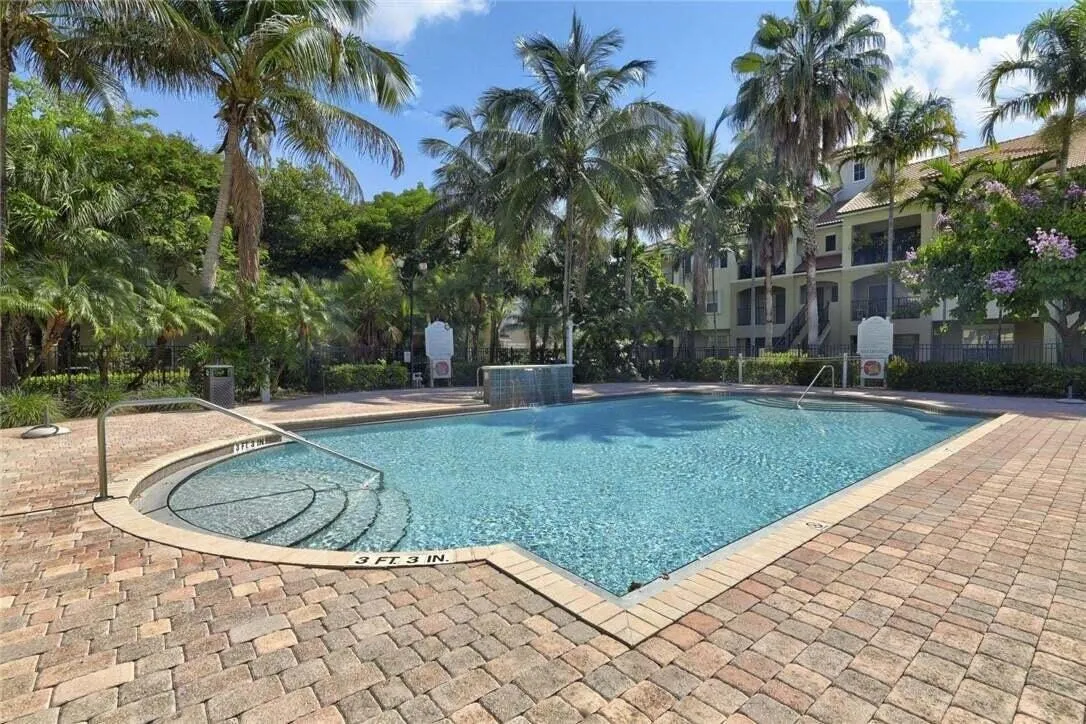 Resort-style pool with integrated steps, surrounded by paver decking
