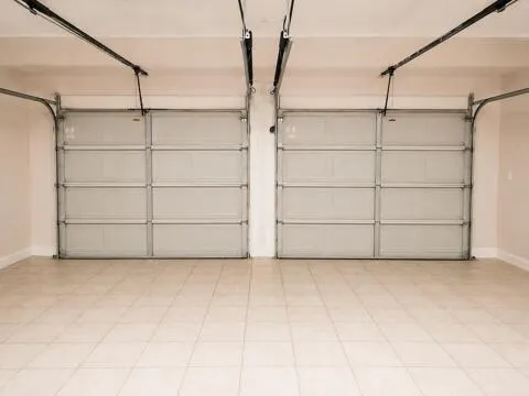 Two-car garage featuring a tiled floor and dual overhead doors with automatic openers