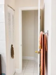 Tile flooring, louvered door, white trim, interior doorway
