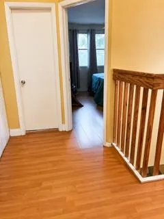 Warm wood-finish flooring throughout, complemented by a natural wood banister