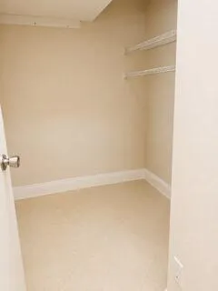 Neutral wall tones, overhead shelving, and tile flooring