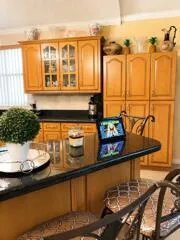 Kitchen featuring wood cabinetry, a built-in pantry, and a breakfast bar with a dark countertop