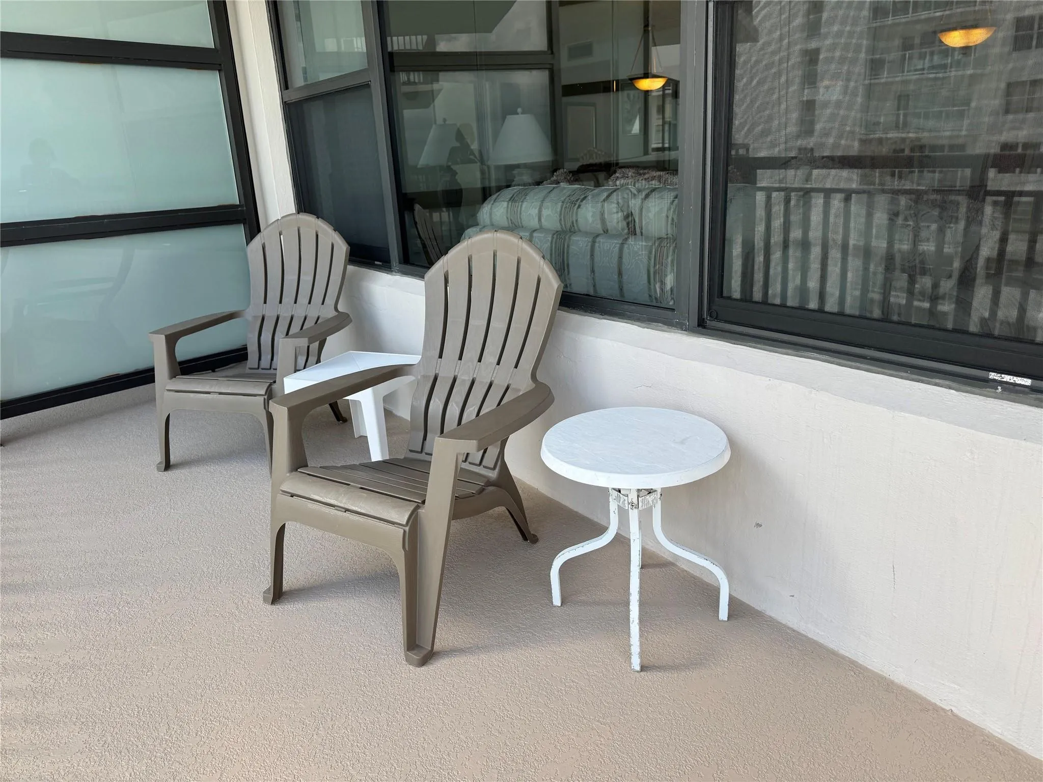 Balcony featuring textured flooring, a smooth perimeter wall, and large windows