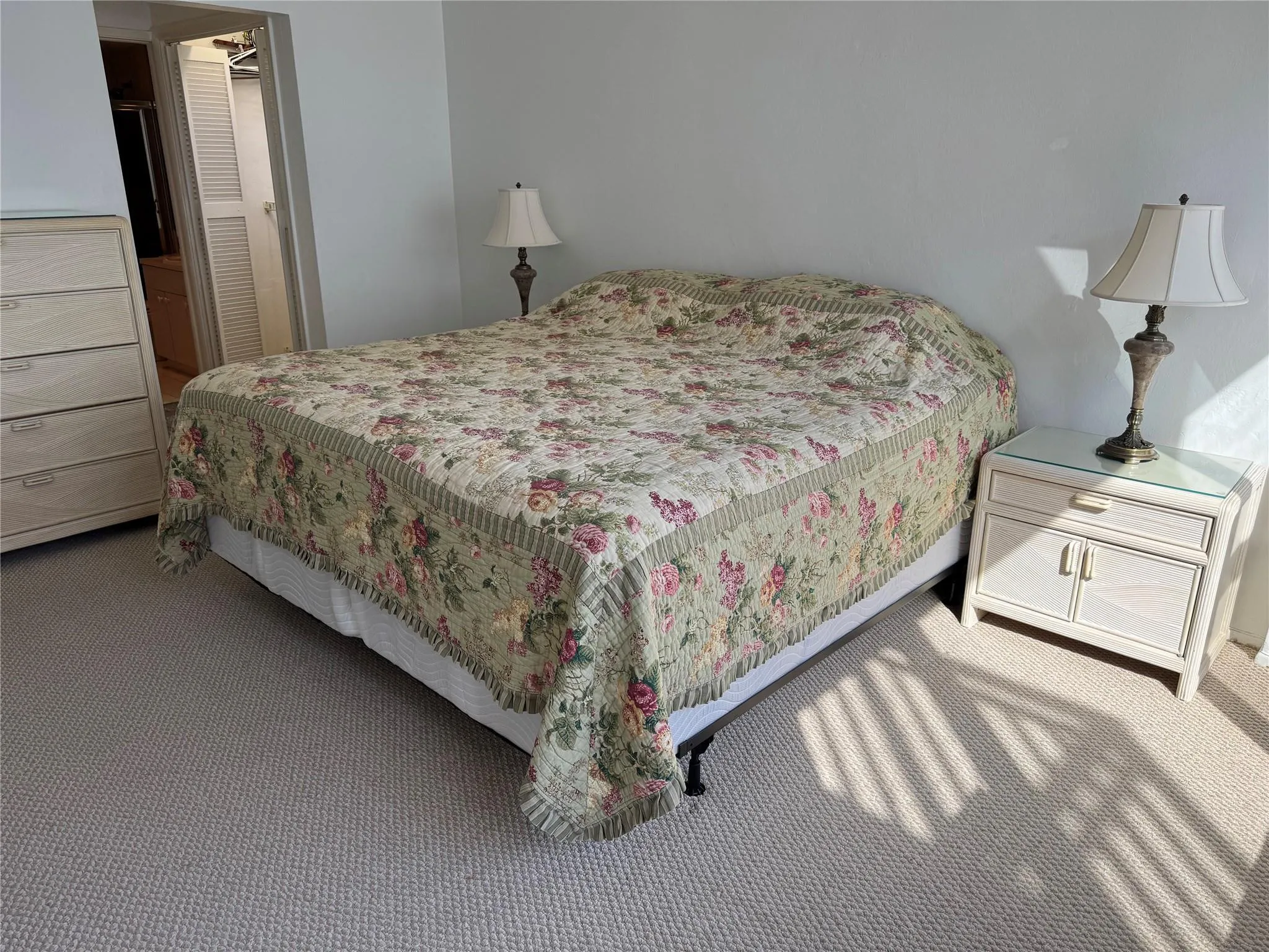 Carpeted flooring, painted walls, and built-in closet with louvered doors