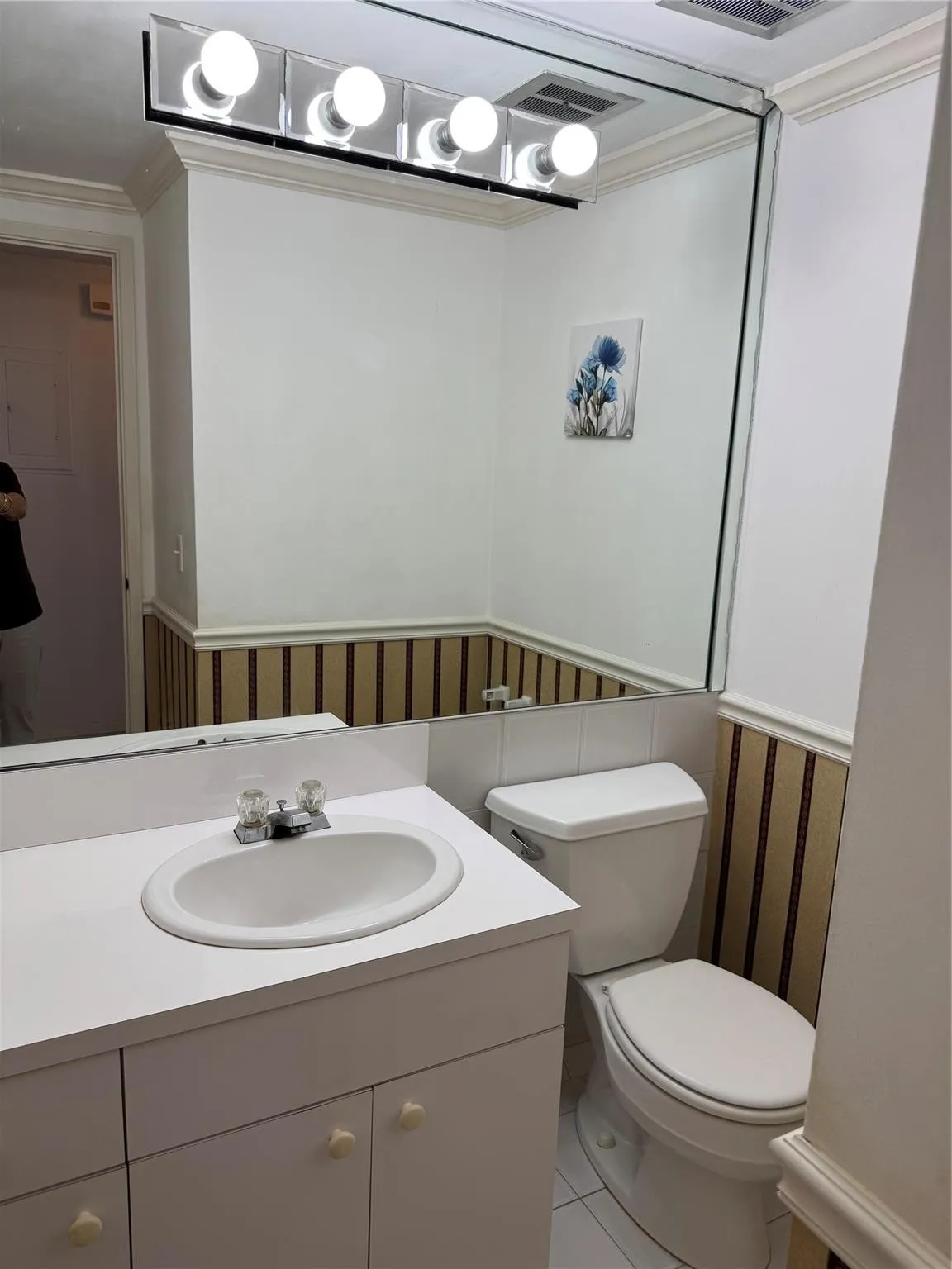 White vanity with integrated sink, chrome faucet, and white cabinetry