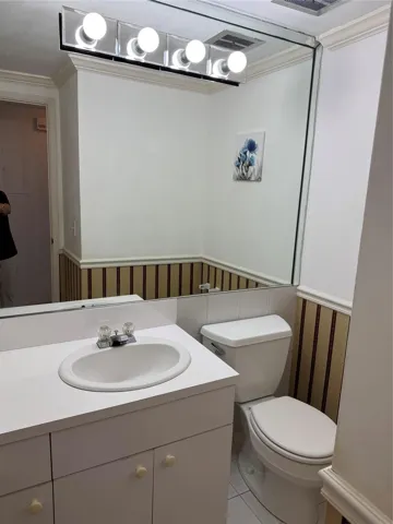 White vanity with integrated sink, chrome faucet, and white cabinetry