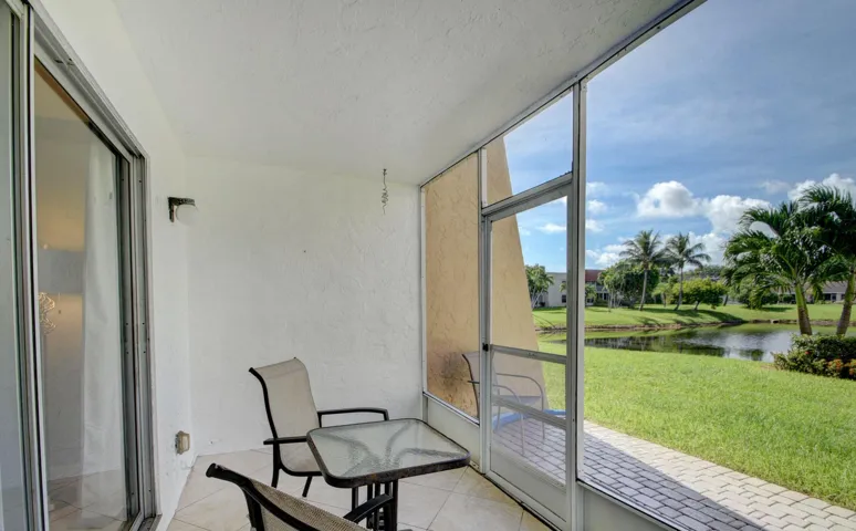 Screened outdoor patio with a tiled floor, plaster wall finish, and sliding glass door access