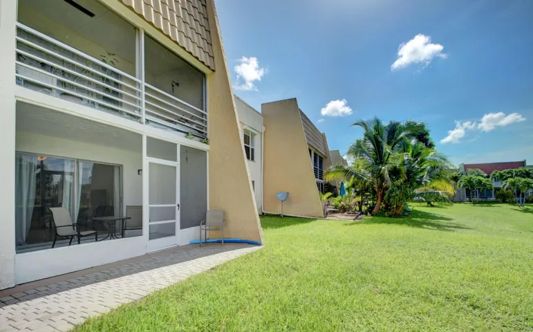 Expansive green space and mature palm trees surround the property