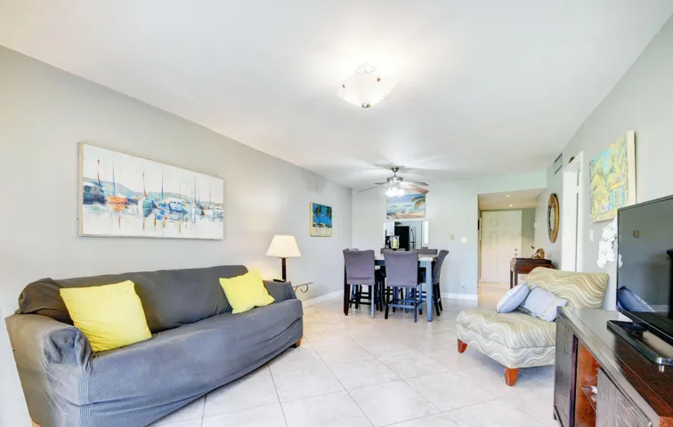 Open concept living area with tiled flooring, neutral wall tones, and overhead lighting
