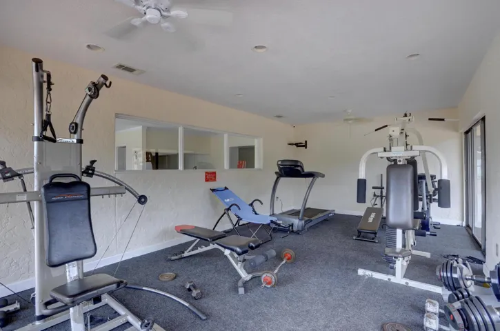 Carpeted exercise room featuring recessed lighting and ceiling fans