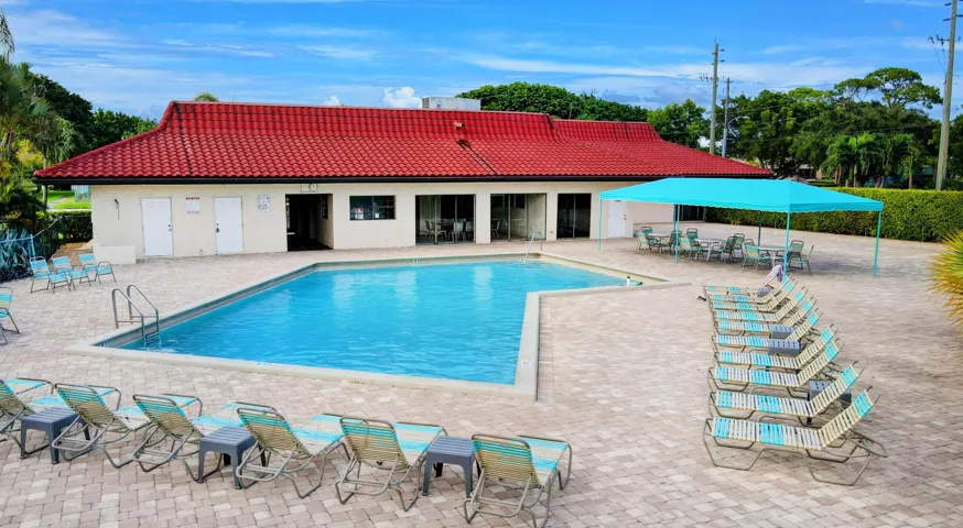 Outdoor swimming pool with integrated steps, surrounded by a paver patio