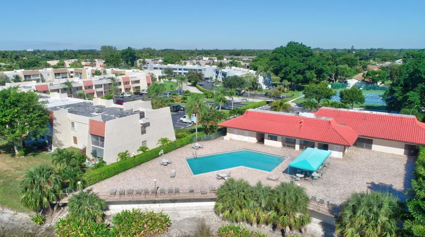Community swimming pool with surrounding paver patio and lounge seating