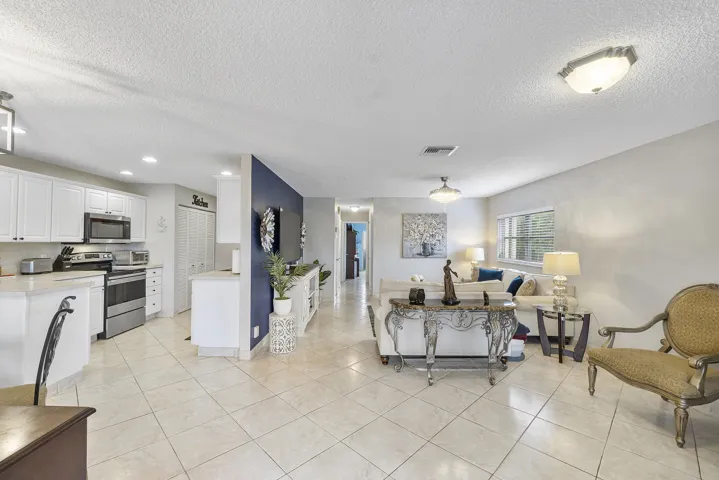View of Living room and dining area with ceramic tiles newer light fixtures