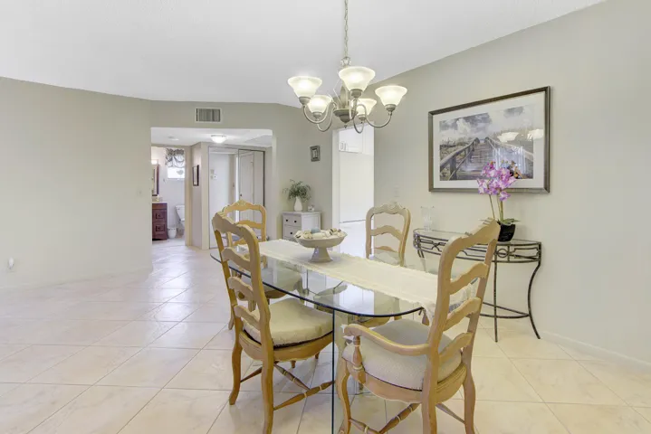 Tiled flooring throughout, recessed lighting in the hallway, and a chandelier fixture