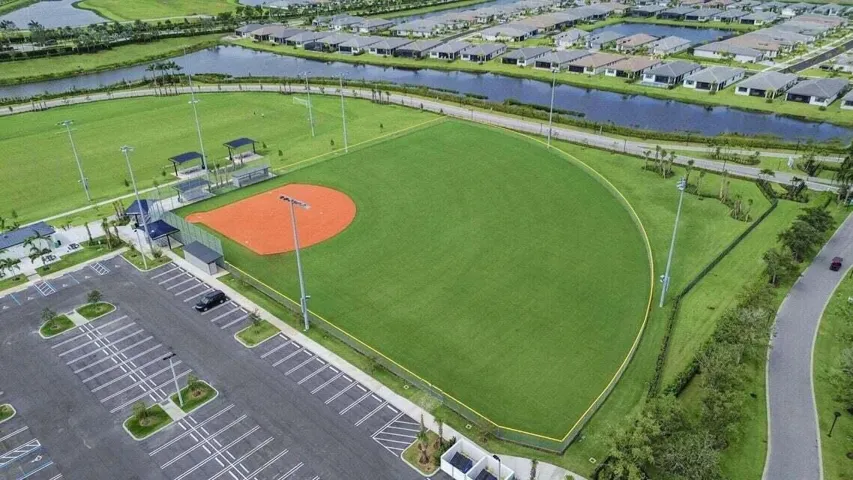 Community amenities include a baseball field, spectator seating, and designated parking areas