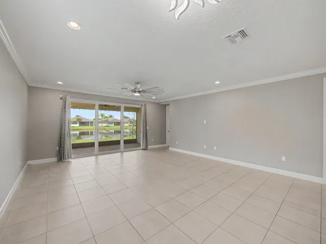 Tile flooring, recessed lighting, crown molding, sliding glass doors, and a ceiling fan