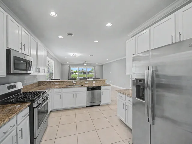 Kitchen featuring stainless steel appliances, white cabinetry, recessed lighting, and tile flooring
