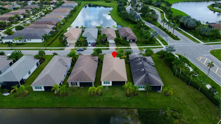 Residential neighborhood featuring multiple single-story homes, paved streets, and a prominent water feature