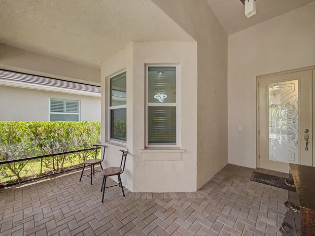 Covered entry with paver flooring, decorative glass entry door, and stucco exterior