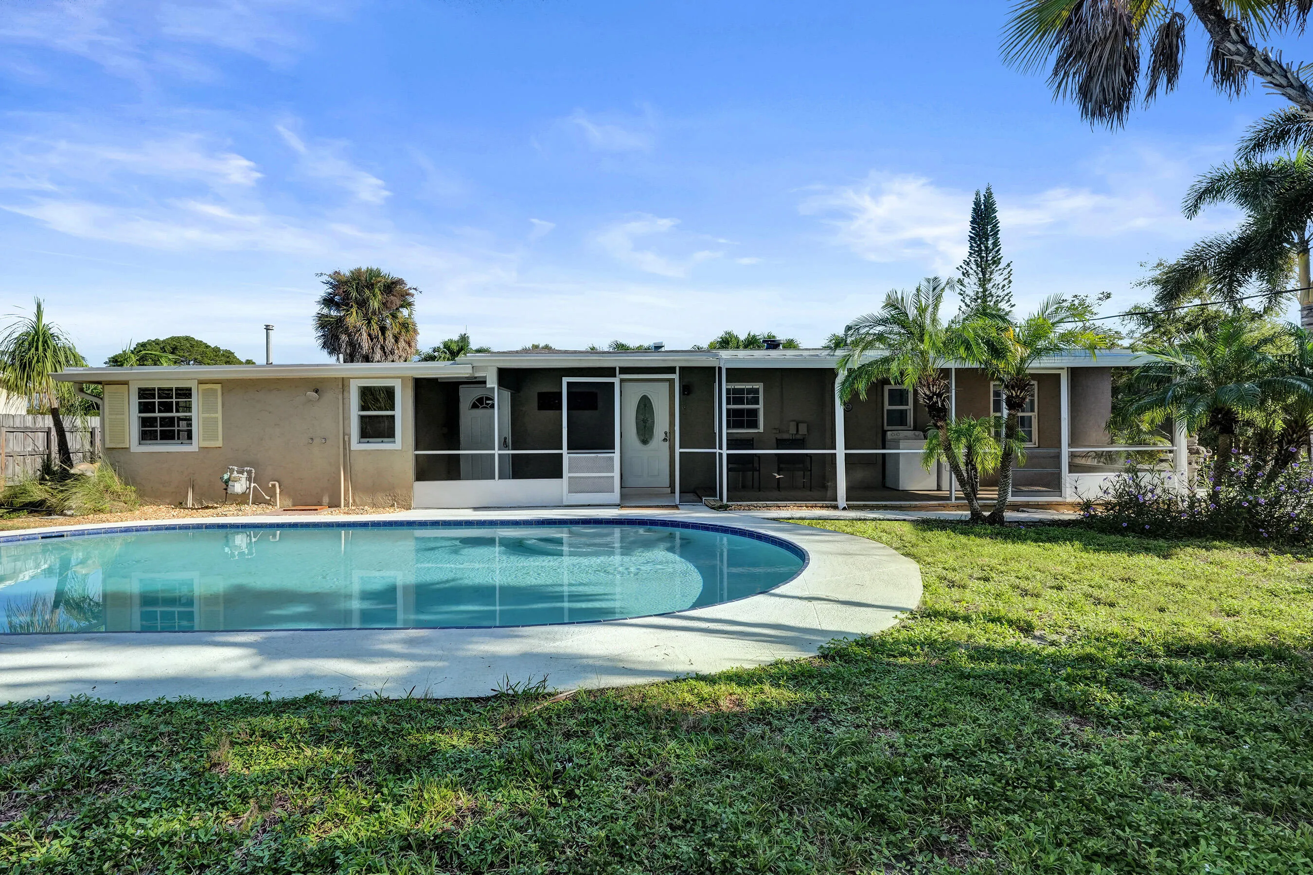 backyard view of pool, house and screen porch