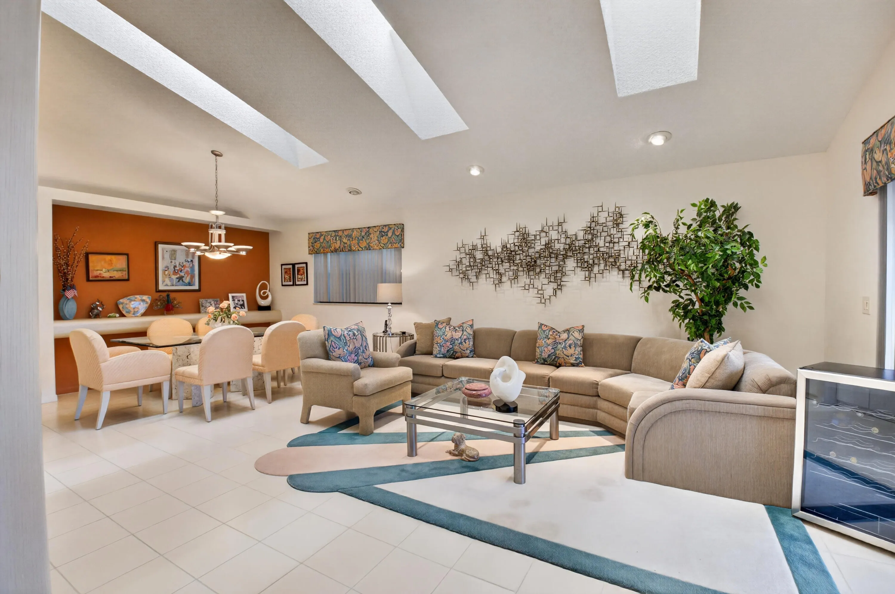 Recessed lighting with skylights illuminating the ceiling, tile flooring, built-in shelving, and a built-in wine refrigerator