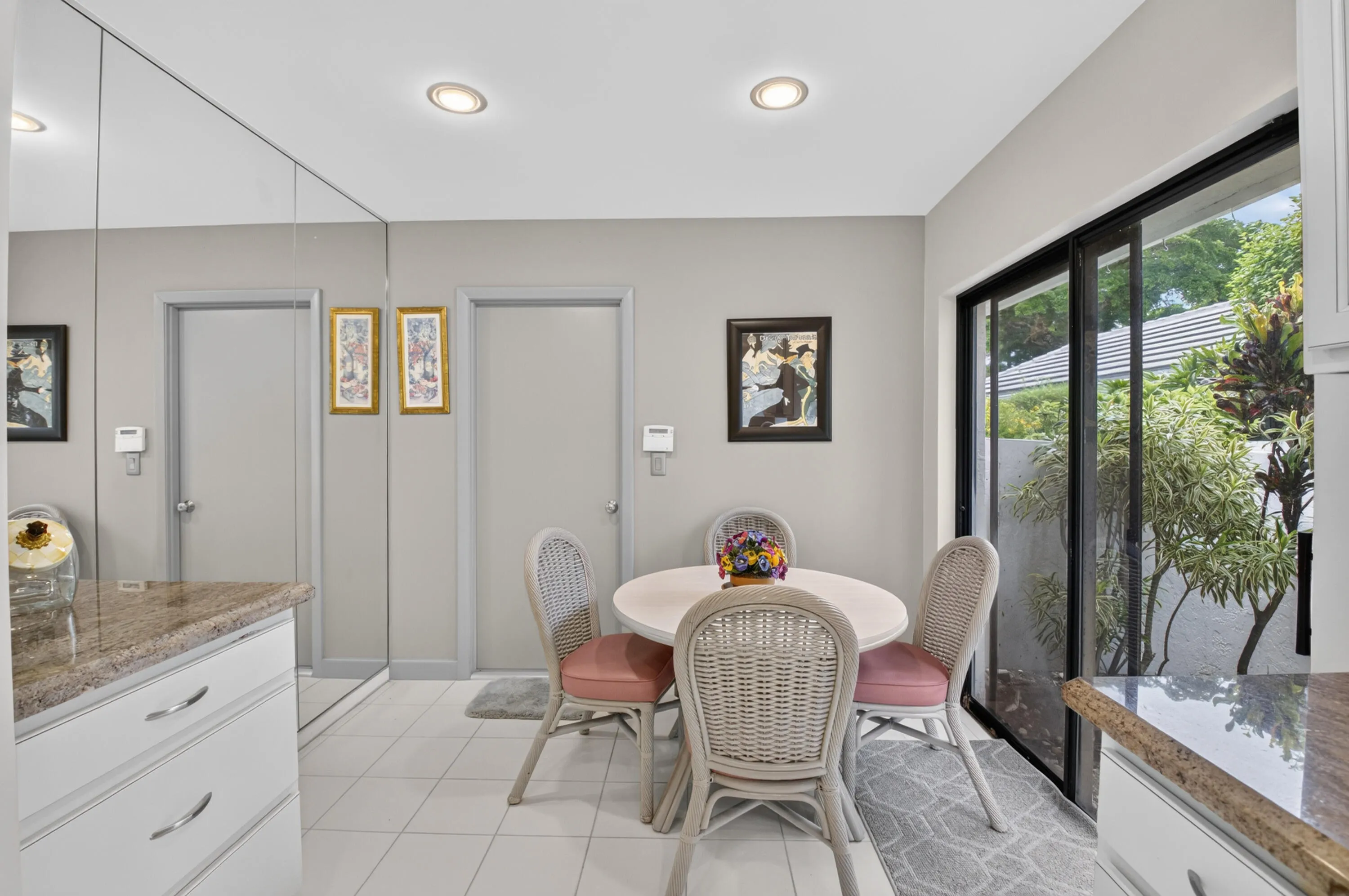 White tile flooring, recessed lighting, mirrored wall, granite-finish countertops, and sliding glass doors