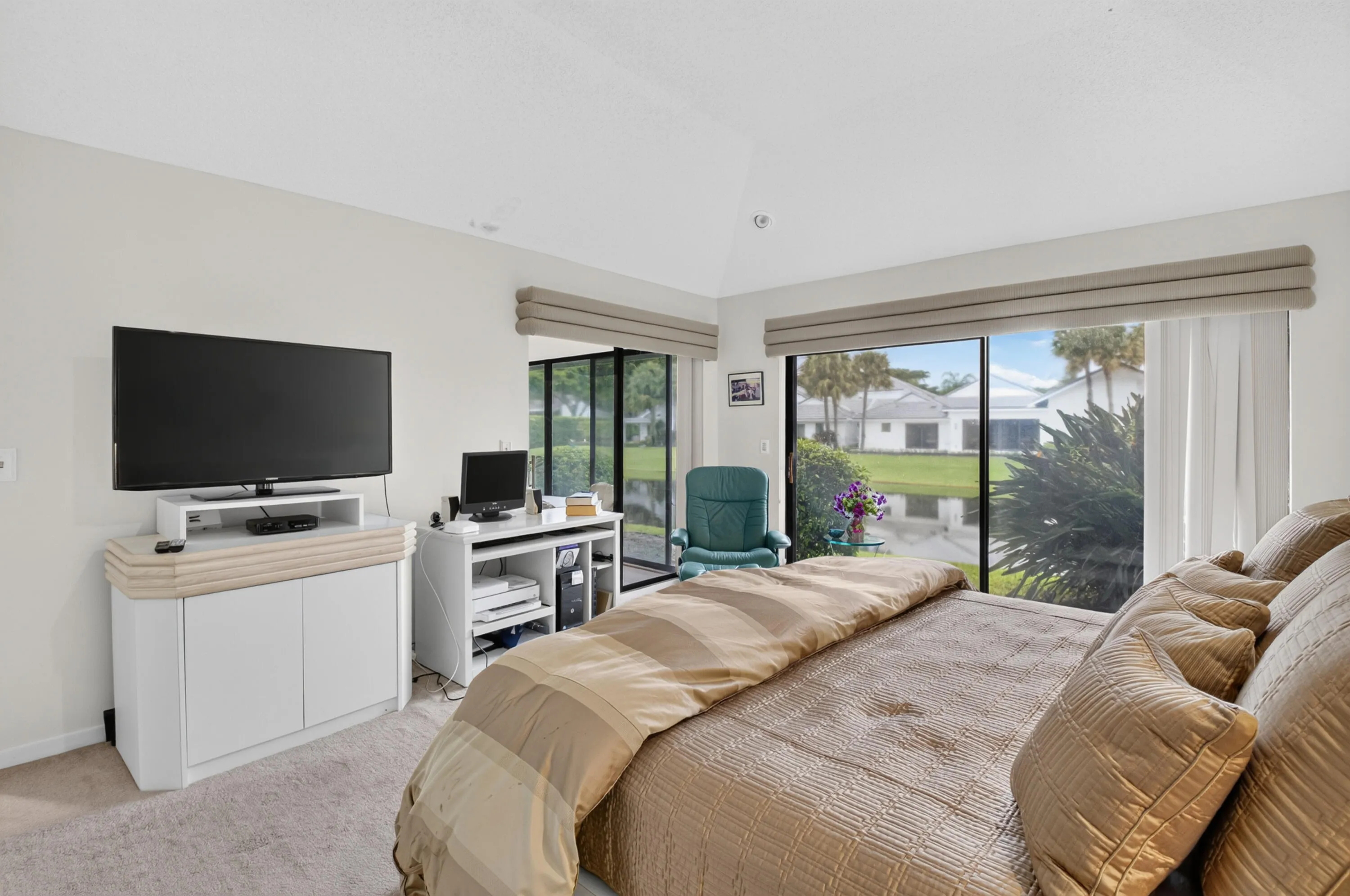Recessed lighting, vaulted ceiling, sliding glass doors, window treatments, and light-colored carpeting