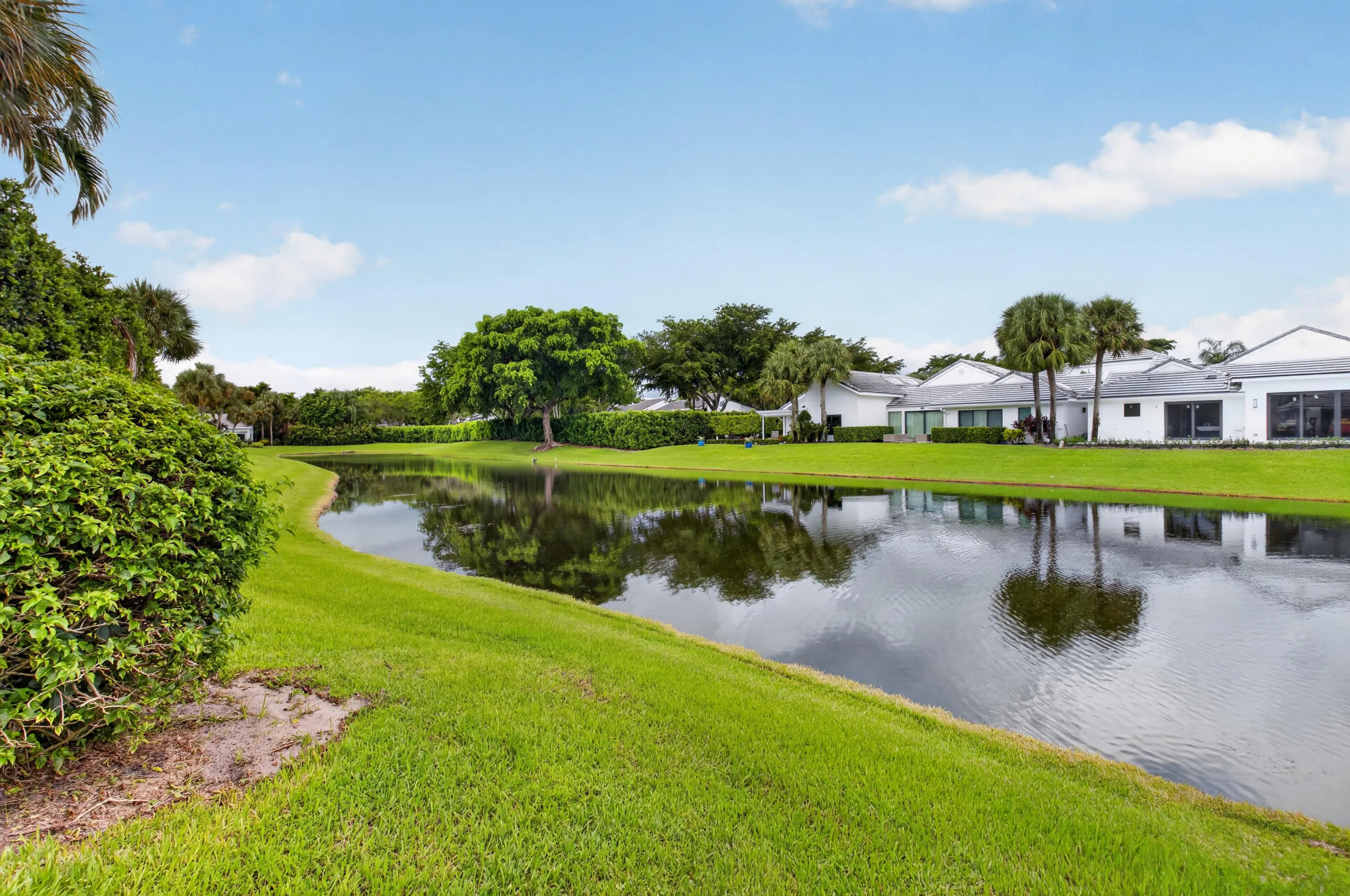 Waterfront property featuring lush green lawns and established landscaping