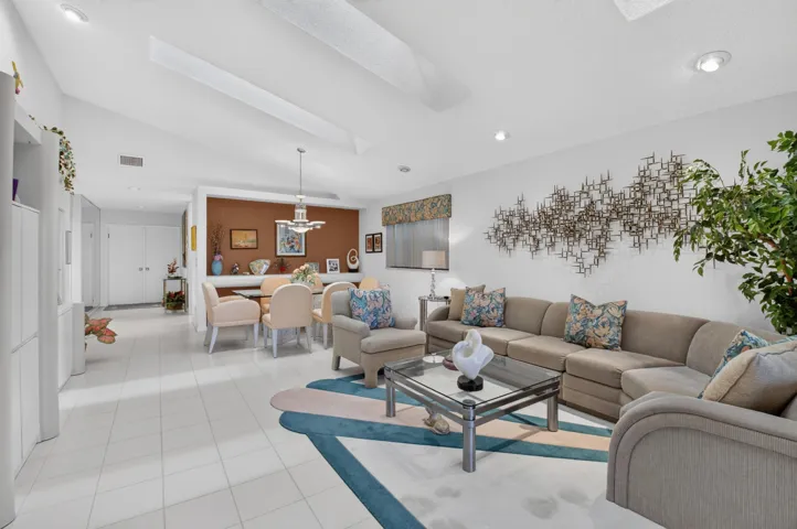 Vaulted ceilings with recessed lighting, tile flooring, built-in cabinetry, and a dining area with a chandelier